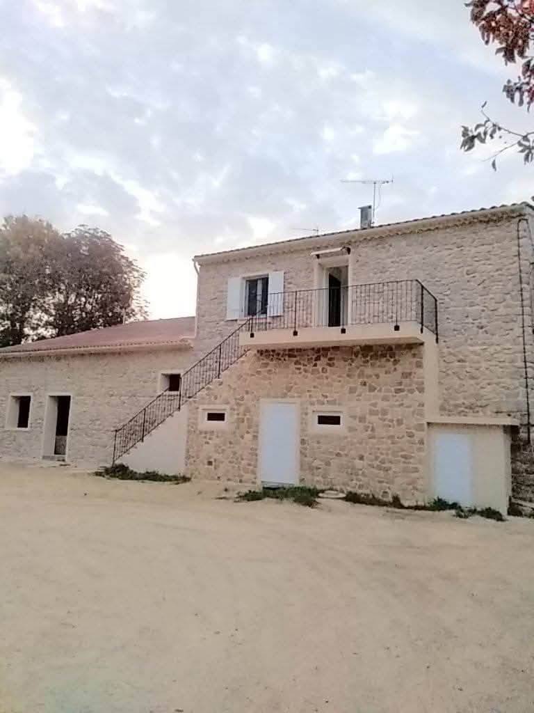 Bâtiment en pierres apparentes entièrement rénové avec escalier extérieur et balcon – après travaux