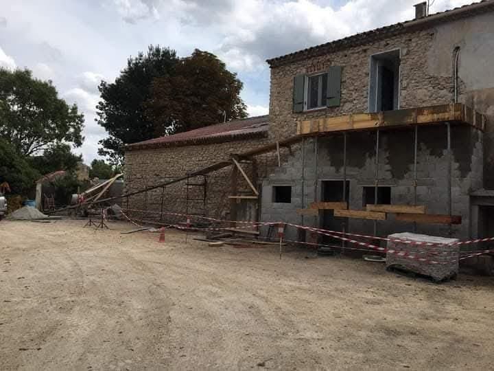 Rénovation structurelle d'un bâtiment en pierre, façade en cours avec échafaudage – pendant les travaux