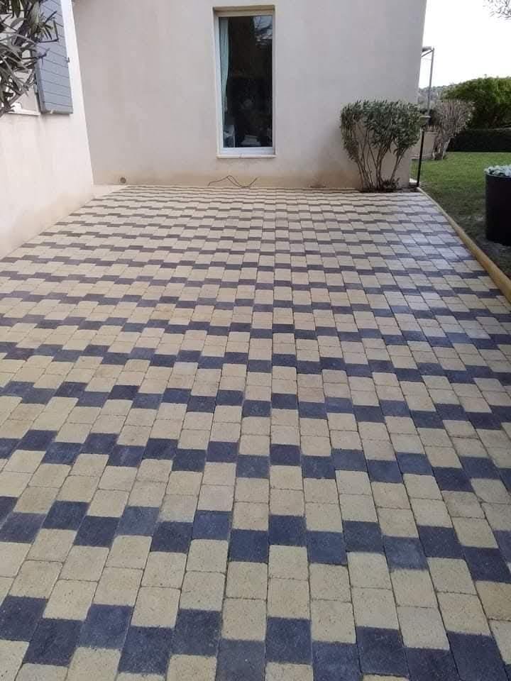 Cour extérieure entièrement pavée avec pavés bicolores beige et anthracite – après travaux